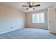 Bedroom featuring carpet flooring, a ceiling fan, closet, and a large window at 2923 Glenhaven Sw Ct, Conyers, GA 30094