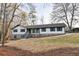 Charming home featuring stone accents, a welcoming front porch, and newly built stairs, surrounded by mature trees at 2923 Glenhaven Sw Ct, Conyers, GA 30094