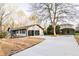 Exterior view of the home featuring a two-car garage, large driveway, and an extra storage building at 2923 Glenhaven Sw Ct, Conyers, GA 30094