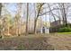 The backyard features a charming storage shed nestled among mature trees at 2923 Glenhaven Sw Ct, Conyers, GA 30094