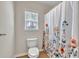Bathroom featuring a toilet, floral shower curtain, window, and neutral walls at 3285 Pebble Ridge Ln, Buford, GA 30519