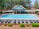Community pool area featuring lounge chairs, tables and a pool house, all enclosed by a fence at 3285 Pebble Ridge Ln, Buford, GA 30519