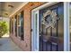 Close-up of the front door featuring a wreath, brick exterior, black shutters, and stylish lighting at 3285 Pebble Ridge Ln, Buford, GA 30519
