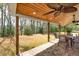 Covered patio with outdoor dining, ceiling fans, brick floors, and a wooded view at 3285 Pebble Ridge Ln, Buford, GA 30519