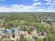Aerial view of a neighborhood with tree-lined streets, showcasing the homes nestled amongst lush greenery and a nearby lake at 465 Hunt River Way, Suwanee, GA 30024
