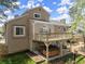 Exterior view of a two-story home with a deck overlooking a hot tub and landscaped yard at 465 Hunt River Way, Suwanee, GA 30024