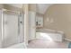 Bright bathroom featuring a shower, a corner tub, and natural lighting from a window at 465 Hunt River Way, Suwanee, GA 30024
