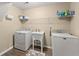 Efficient laundry area includes washer, dryer, utility sink, and storage shelving for convenience at 465 Hunt River Way, Suwanee, GA 30024