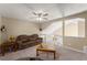 Upstairs living room with a comfortable brown couch, glass coffee table, and ceiling fan at 465 Hunt River Way, Suwanee, GA 30024