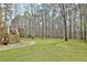 Expansive backyard featuring lush lawn, mature trees, and a patio area for outdoor entertaining at 155 Woodcreek Ln, Fayetteville, GA 30215