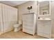 Bathroom with tile floor, toilet, white cabinet, flowers in vase, mirror, and striped shower curtain at 155 Woodcreek Ln, Fayetteville, GA 30215