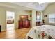 Bedroom view with hardwood floors, entertainment center, and open archway to a luxurious soaking tub at 155 Woodcreek Ln, Fayetteville, GA 30215