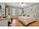 Bright bedroom with light blue walls, hardwood floors, a ceiling fan, and two windows at 155 Woodcreek Ln, Fayetteville, GA 30215