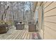 Wooden deck with seating, a table, an umbrella, and a view of the backyard woods at 155 Woodcreek Ln, Fayetteville, GA 30215