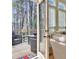 View of a wooden deck through a sliding glass door with outdoor seating surrounded by trees at 155 Woodcreek Ln, Fayetteville, GA 30215