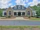 Stunning home with a combination of stone and siding, complemented by lush landscaping and manicured lawn at 155 Woodcreek Ln, Fayetteville, GA 30215