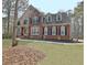 Charming two-story brick home with a manicured lawn and classic architectural details at 155 Woodcreek Ln, Fayetteville, GA 30215