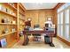 Home office with wood paneled walls, built-in bookshelves, and shuttered windows at 155 Woodcreek Ln, Fayetteville, GA 30215