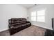 Bedroom with a brown leather sofa, carpet flooring, and natural light, creates a cozy retreat at 2026 Forte Ln, Alpharetta, GA 30009