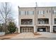 Charming townhome features a two-car garage and upper level porch with view of a landscaped yard at 2026 Forte Ln, Alpharetta, GA 30009