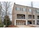 Charming townhome with a two-car garage, upper level porch, and brick architectural elements at 2026 Forte Ln, Alpharetta, GA 30009