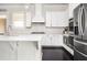 Bright kitchen featuring stainless steel appliances, white cabinets, countertops and hardwood flooring at 2026 Forte Ln, Alpharetta, GA 30009