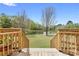 Scenic backyard view with wooden deck, tranquil pond, and lush green landscape at 2503 Westchester Se Way, Conyers, GA 30013