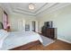 Relaxing main bedroom with tray ceiling, warm colors, and wood flooring at 2503 Westchester Se Way, Conyers, GA 30013