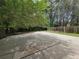 Expansive backyard featuring a concrete patio, surrounded by a wood fence and mature trees at 3512 Ten Oaks Ct, Powder Springs, GA 30127