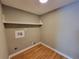 Compact laundry room with washer and dryer hookups and overhead shelving at 3512 Ten Oaks Ct, Powder Springs, GA 30127