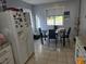 Bright kitchen featuring a dining area with tiled flooring and a white refrigerator at 3657 Willow Wood Way, Lawrenceville, GA 30044