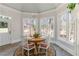 Bright breakfast nook features a round table, chandelier, and walls of windows offering views of the outdoors at 1130 Martins Chapel Rd, Lawrenceville, GA 30045