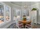 Breakfast nook with a round wooden table, four chairs, chandelier, and large windows providing a view of the backyard at 1130 Martins Chapel Rd, Lawrenceville, GA 30045