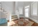Bright foyer with wood floors, area rug, staircase, and glass-paneled front door with sidelights at 1130 Martins Chapel Rd, Lawrenceville, GA 30045