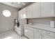 Well-lit laundry room features white cabinets, countertop, and modern washer and dryer at 1130 Martins Chapel Rd, Lawrenceville, GA 30045