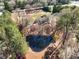 Aerial view of property featuring a serene pond reflecting the surrounding trees, offering a peaceful retreat at 1130 Martins Chapel Rd, Lawrenceville, GA 30045