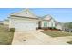 Well-maintained home featuring a two-car garage, stone accents, and a landscaped yard with colorful flower beds at 1640 Andalusian Way, Conyers, GA 30012