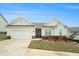 Well-maintained single-story home featuring a two-car garage, landscaped yard with flower beds, and stone accents at 1640 Andalusian Way, Conyers, GA 30012
