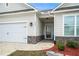 Well-maintained home featuring a two-car garage, front door, and a landscaped yard with stone accents at 1640 Andalusian Way, Conyers, GA 30012