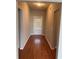 Hallway with hardwood floors leading to an exterior door and featuring neutral-colored walls at 1640 Andalusian Way, Conyers, GA 30012