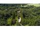 Expansive aerial view of a luxurious estate nestled among lush, mature trees and a private pond at 2100 West Wesley Rd, Atlanta, GA 30327