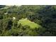 Overhead view of wooded acreage featuring a pond, manicured lawn, and winding driveway leading up to the house at 2100 West Wesley Rd, Atlanta, GA 30327