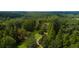 Scenic aerial view of a wooded area with a path leading to a tranquil pond and lush greenery at 2100 West Wesley Rd, Atlanta, GA 30327