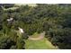 Aerial view of wooded land featuring a pond, manicured lawn, and winding driveway leading to the house at 2100 West Wesley Rd, Atlanta, GA 30327