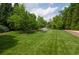 Expansive backyard featuring a lush lawn, pond with fountain, and mature trees providing shade and privacy at 2100 West Wesley Rd, Atlanta, GA 30327
