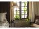 Cozy bedroom showcasing natural light from the window and an elegant, vintage-style lamp at 2100 West Wesley Rd, Atlanta, GA 30327