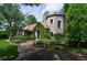 Stone house with a quaint entryway covered in vines, complemented by mature landscaping and a stone pathway at 2100 West Wesley Rd, Atlanta, GA 30327