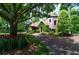 Stone home surrounded by mature trees and colorful landscaping with a charming pathway to the front entrance at 2100 West Wesley Rd, Atlanta, GA 30327