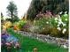 A colorful garden with stone retaining wall and lush green grass at 2100 West Wesley Rd, Atlanta, GA 30327