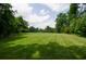 Large, well-manicured lawn with mature trees in the background at 2100 West Wesley Rd, Atlanta, GA 30327